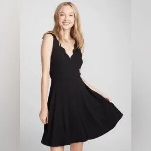 Twik (Simon's) black sleeveless dress with scalloped detailing.